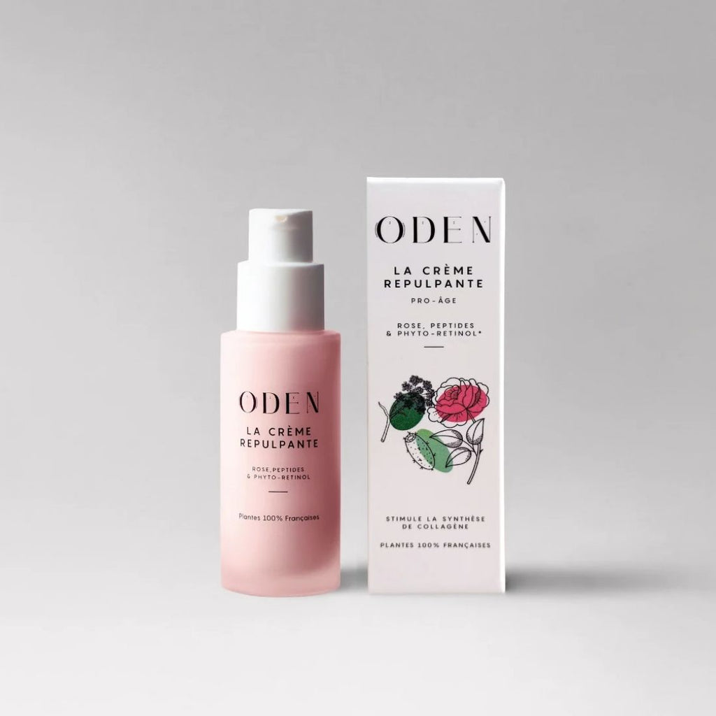 A pink pump bottle and its white rectangular box for Oden La Crème Repulpante, displayed on a clean light gray background.