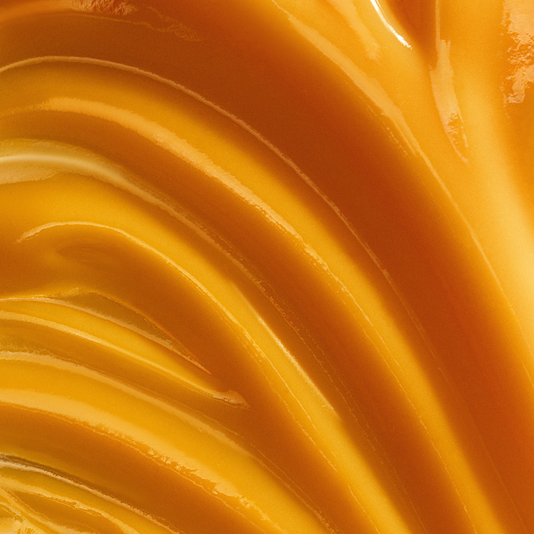 Close-up of smooth, orange-colored cream with concentric circles.