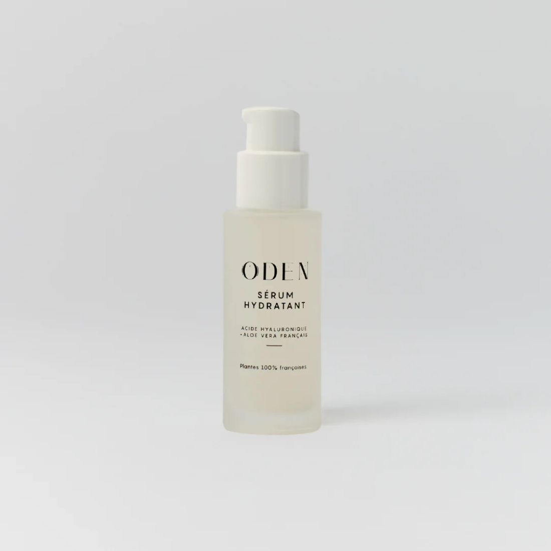 Skincare serum bottle labeled 'ODEN on a light gray background