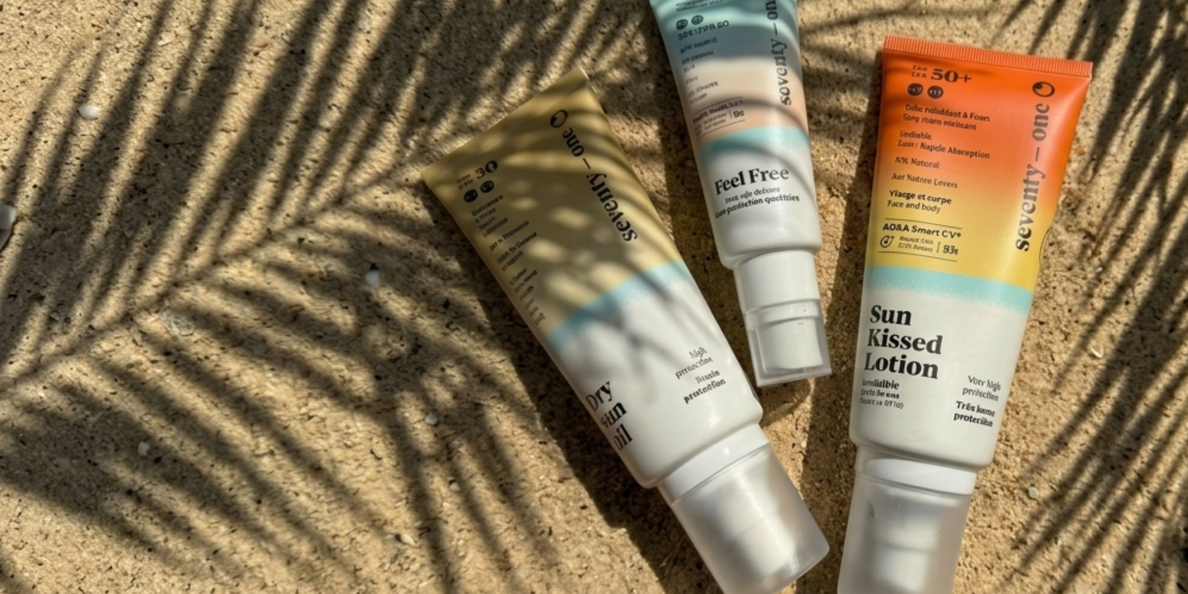 Three skincare products on a sandy surface with palm leaf shadows
